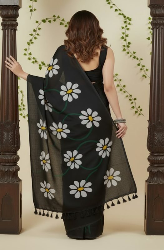 Woman draping a soft black mul saree with handpainted white daisy flowers, showing lightweight and breathable texture perfect for office wear back view draped on model by swamini sarees